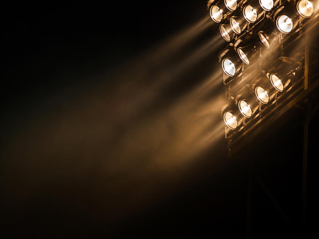 Stadium floodlights glowing warm amber against a night sky